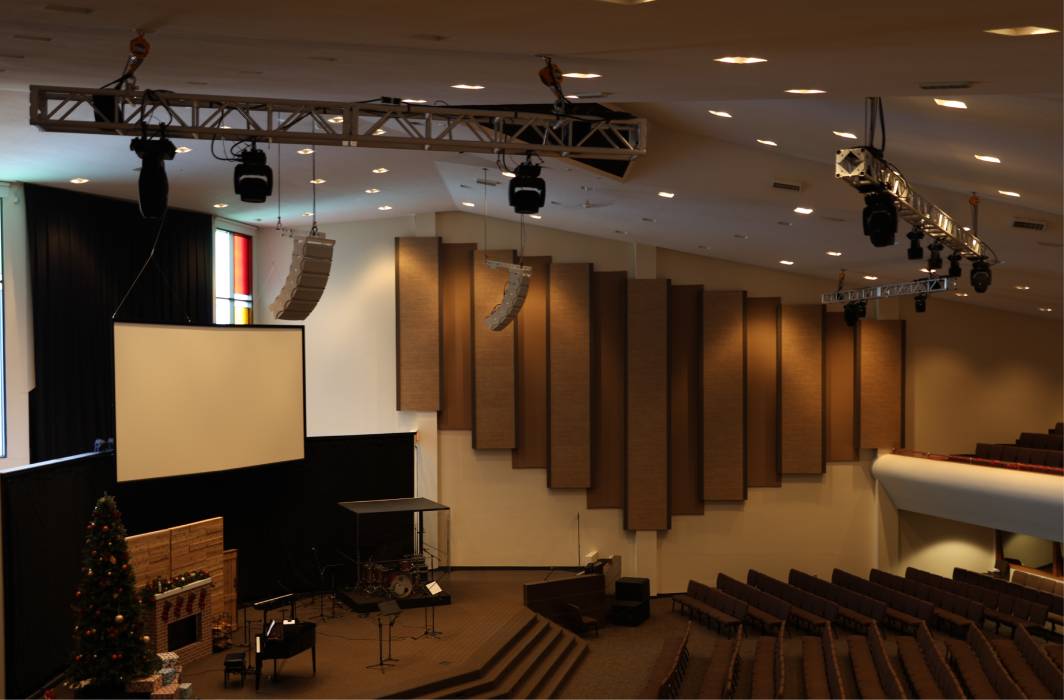 Side image of a church with rigging suspened from the roof holding speakers and lighting equipment.