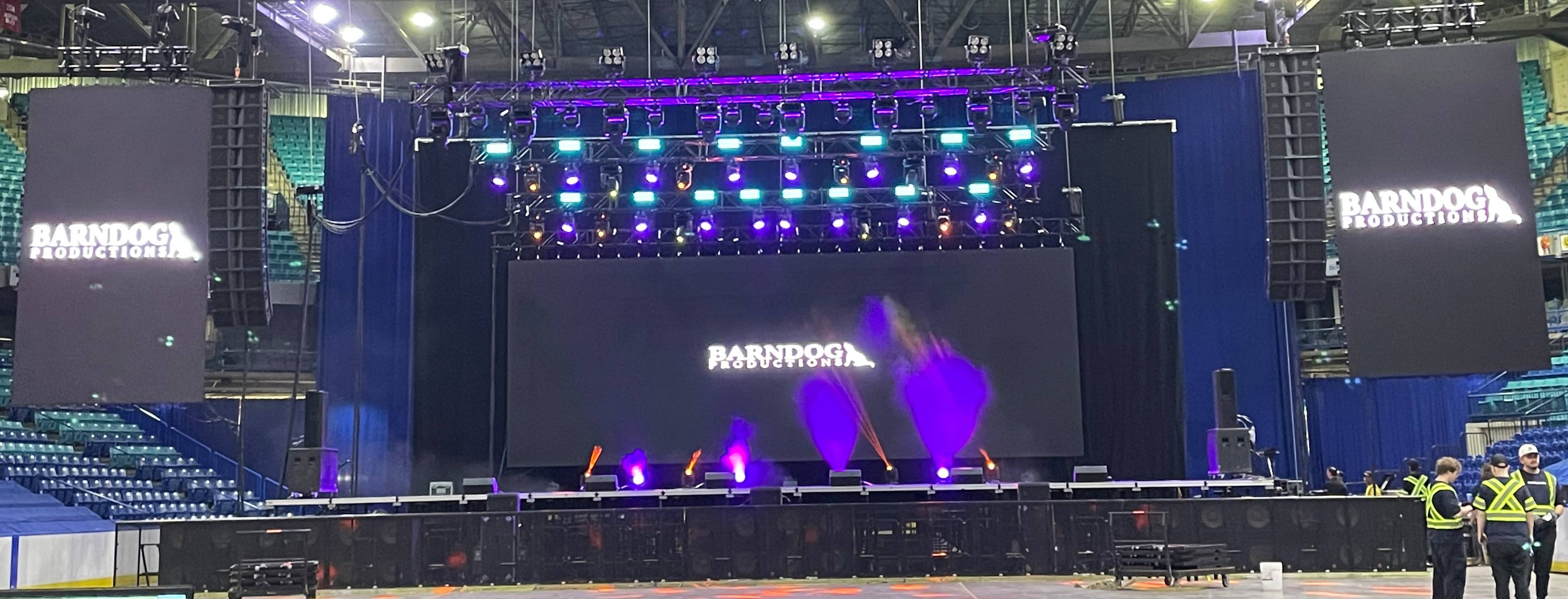 stage with lighting and a video wall on it with one hanging video walls on both side of the stage